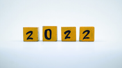 Wooden block calendar with numbers for 2022. Yellow on a white background