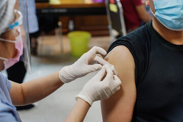 Doctor holding syringe and  make injection Covid-19 or coronavirus vaccine to patient