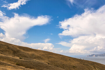 Small figures of people on the rise of the mountain