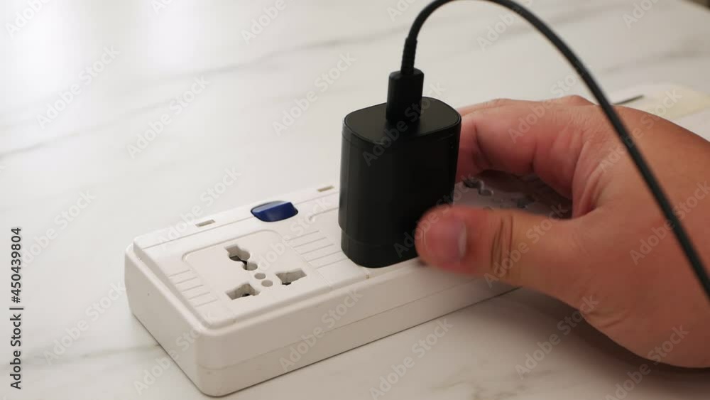 Poster close up man hand unplugging phone adapter battery and turn off the switch with removing the charger
