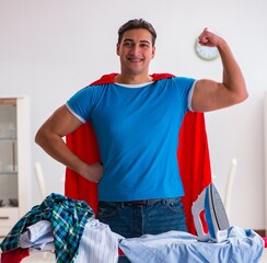 Super hero man husband ironing at home