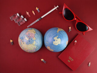 Vaccine passport red sunglass world atlas globe map north south pole on red paper background world travel tour vacation mini human figures medical needle syringe bottle