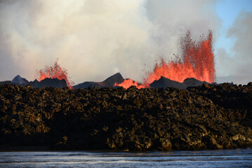 The 2014 Bárðarbunga eruption at the Holuhraun fissures and its advancing lava flow as seen from across a glacial river, Central Highlands, Iceland