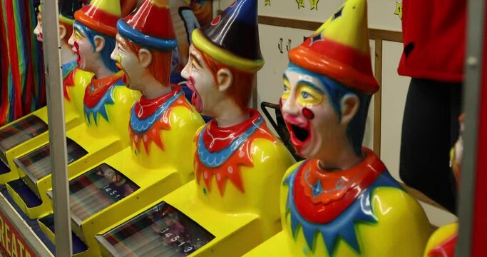 Carnival Amusement row of laughing clowns rotating at night