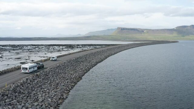 Aerial View Of Vehicles Traveling At The Asphalt Road On The Coastline In Westfjords, Iceland. 