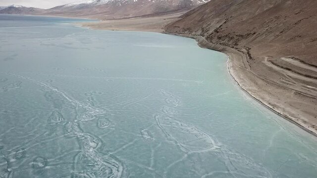 4K on Blue Ice surface of Frozen Lake from drone aerial view at Pangong Lake or Pangong Tso, Tso moriri – Nubra, India. Abstract concept of Cold winter, peaceful and freedom.