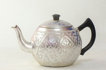 Carved aluminum pot on white background and texture.