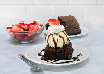 Brownie sundae with whipped cream, vanilla ice cream & strawberries.