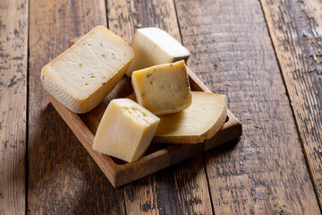 Various types of cheese on tray on wooden table. Cheese plate. Copy space.