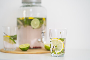 Summer cooling drink with berries and citrus. Lemonade in a reusable glass bottle and glasses. Homemade drink with mint, lime and lemon. Medicinal and healthy drink with vitamin C