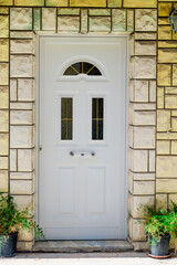 entrance white door with a house in a laconic style close-up