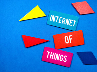 Business concept.Text INTERNET OF THINGS writing on colored wooden board with wooden puzzle on blue background.
