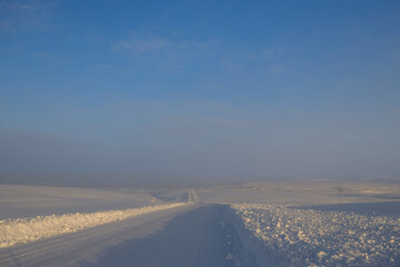 In front of us is a road that goes into the distance in the middle of a snowy desert. The road to Teriberka