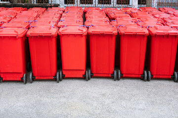Rows of red hazardous waste bins are neatly packed with rubbish from COVID-19 patients behind the...