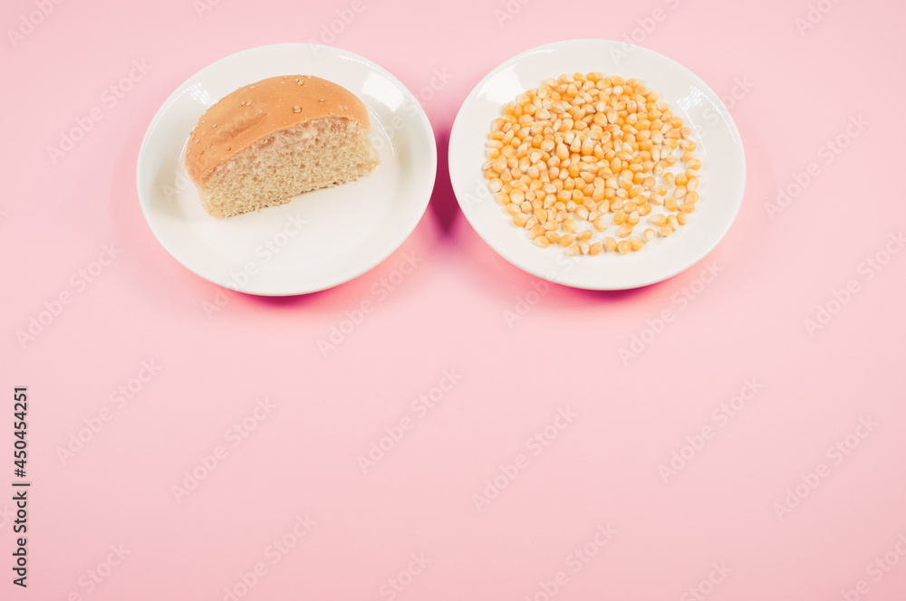 Sticker Top view of half bread bun and corn grains on a plate isolated on pink background