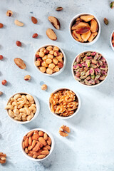 Many different nuts, shot from above with copyspace, Pistachios, walnuts, almonds and many other nuts in bowls