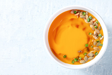 Butternut squash cream soup with green onions, shot from the top with a place for text. Healthy vegan dinner