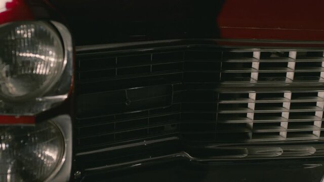 Detail shot of the headlights of a red Cadillac DeVille from the 60s.