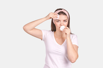 Pretty young woman gesture. Studio portrait. Female person. Isolated background. Morning bathroom routine. round cotton pad. Facial clean concept. Remove makeup lotion