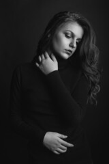 Elegant model with curly long hair wears black turtleneck