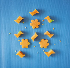 Geometric shapes made of sliced melon and melon seeds lay down on a pastel blue background. Summer refreshment minimal concept, flat lay composition