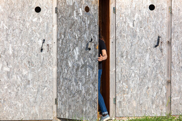 The girl goes to the wooden toilet