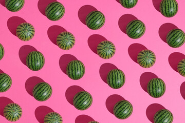 Watermelons lay down on a pastel pink background, pattern summer concept