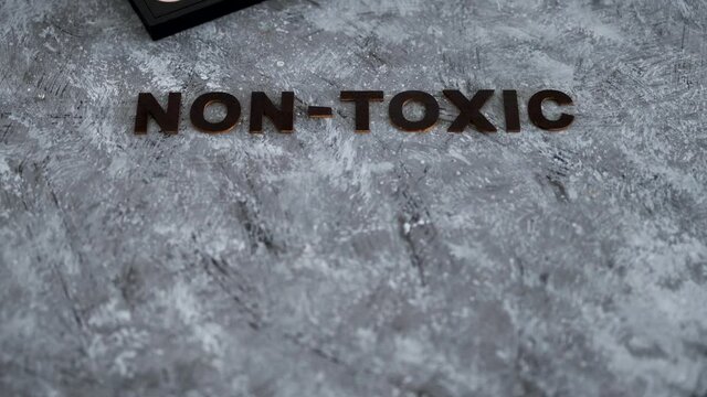 low tox and natural beauty products, make-up palette with non-toxic text on grey background