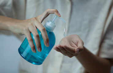 Young woman's hand sprays hand sanitizer gel