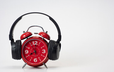 Fototapeta na wymiar Red Alarm Clock put on headphones