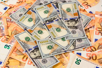 Fototapeta na wymiar Many dollars and euros, texture of money, the advantage of the euro over the dollar.