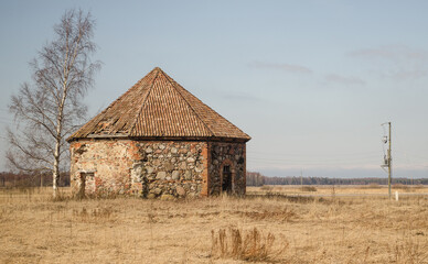 An old, abandoned windmill with a tiled roof.