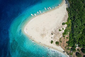 Aerial top down view to the beach of Marathonisi, Turtle island, with boat traffic and tourists enjoying the turquoise sea, Zakynthos, Greece