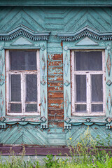 A windows decorated with carved platbands in an old wooden house