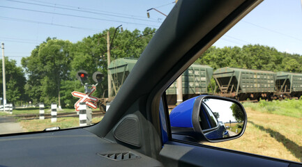 Vehicle Stopped In Front Of Railway Semaphore With Train At Railroad Crossing
