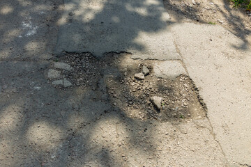 A damaged road, a hole in the asphalt is a danger for drivers