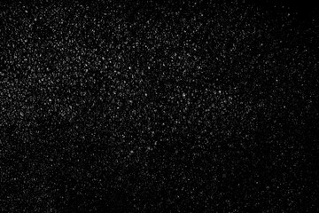 Falling snow on a black background. small particles with bright dots starry sky. Сhaotic white bokeh. light spots texture. abstract.