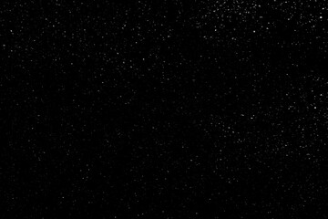 Falling snow on a black background. small particles with bright dots starry sky. Сhaotic white bokeh. light spots texture. abstract.