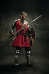 Portrait of one brutal bearded man, medeival warrior or knight with dirty wounded face. Full length