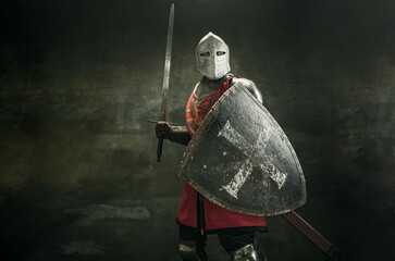 One medeival warrior or knight in armor and helmet with shield and sword - obrazy, fototapety, plakaty