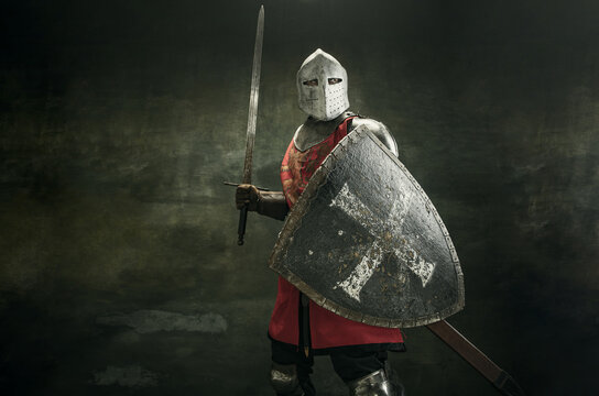 One medeival warrior or knight in armor and helmet with shield and sword