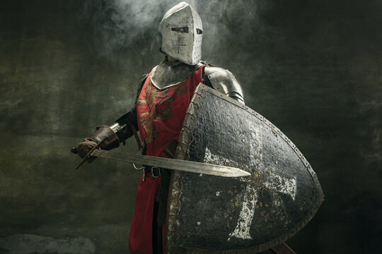 One medeival warrior or knight in armor and helmet with shield and sword
