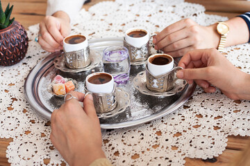 Group of people on the hands drinking turkish coffey, top view