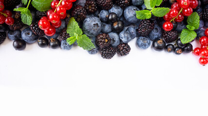 Ripe raspberries, blueberries, blackberries, red and blackcurrants on white background. Background of mix fruits with copy space for text. Mix berries on white background.