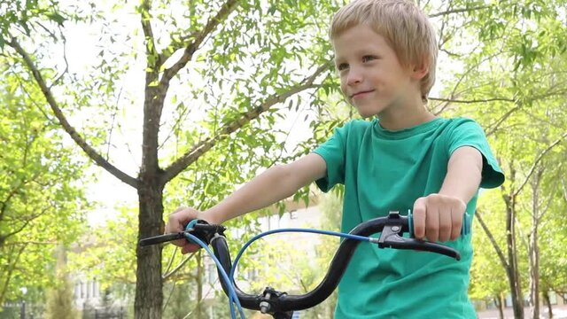 Boy sitting on bike, cycling outdoors
