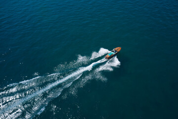 Classic Italian wooden boat fast moving aerial view. Top view of a wooden open large motor boat....