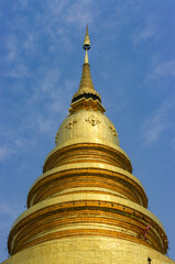 Naklejka premium View of golden stupa or chedi at historical landmark buddhist temple Wat Phra That Hariphunchai, Lamphun, Thailand