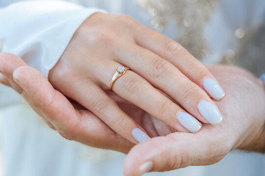 A woman's palm with a gold ring on her finger lies in a man's palm Stock  Photo | Adobe Stock