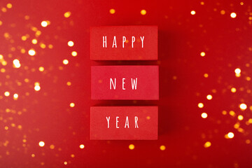 Happy New Year red minimal concept with golden bokeh. Modern flat lay with red toy blocks with...