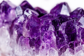 Macro mineral stone purple amethyst in crystals on a white background